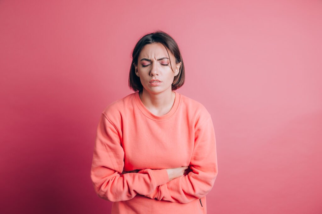 woman-wearing-casual-sweater-background-suffering-stomach-ache-with-painful-grimace-feeling-sudden-period-cramps-gynecology-concept-scaled