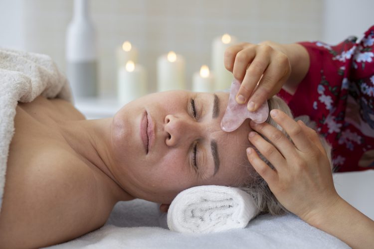high-angle-hand-using-gua-sha-face-massage